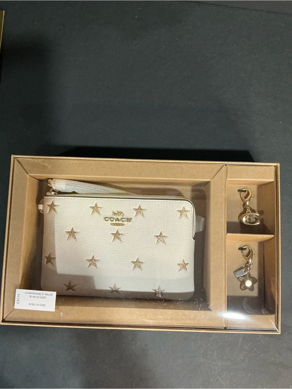 The Coach Boxed Corner Zip Wristlet With Star Print And Charms